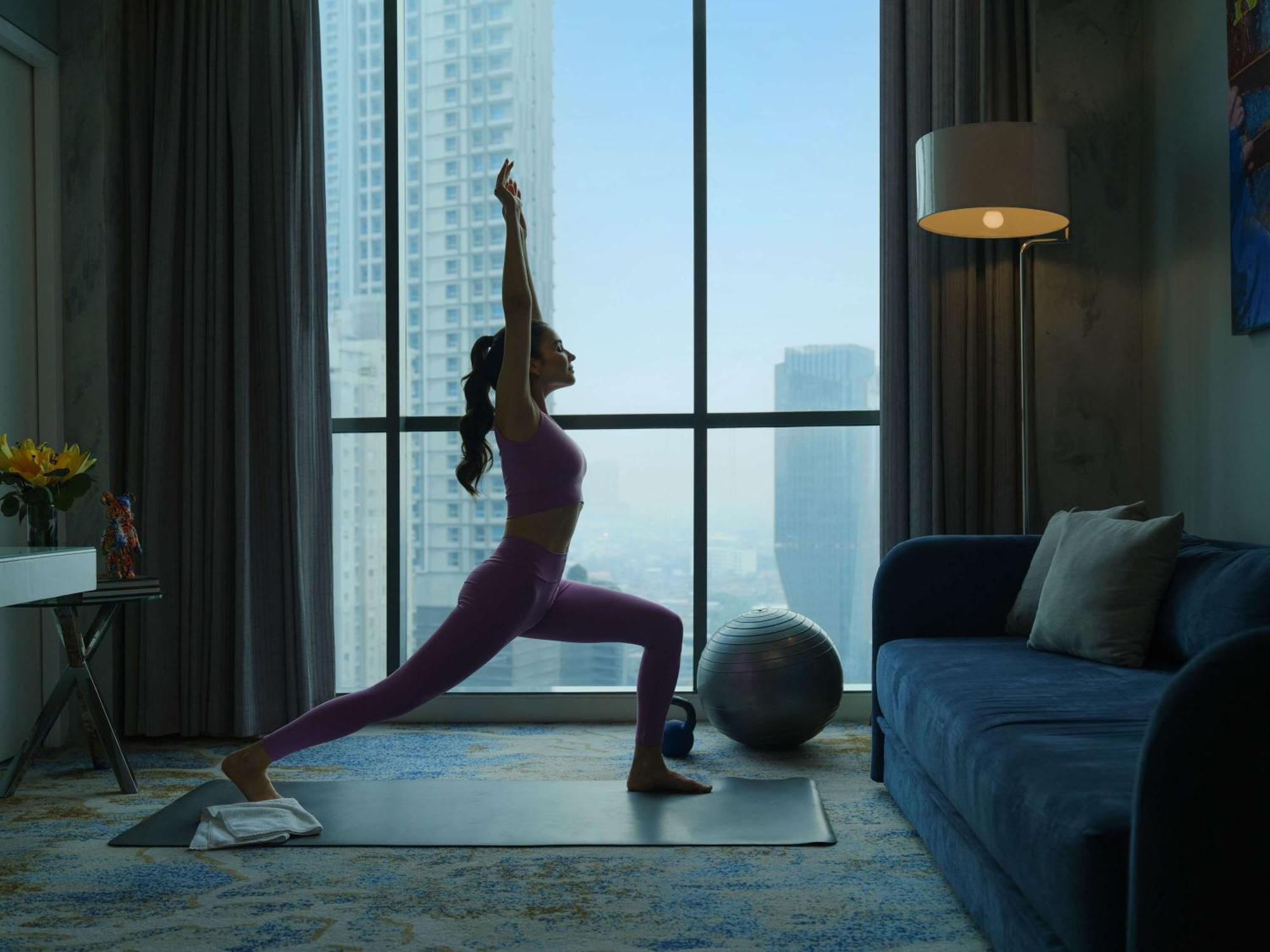 Pullman Jakarta Central Park Zewnętrze zdjęcie A woman practicing yoga at home